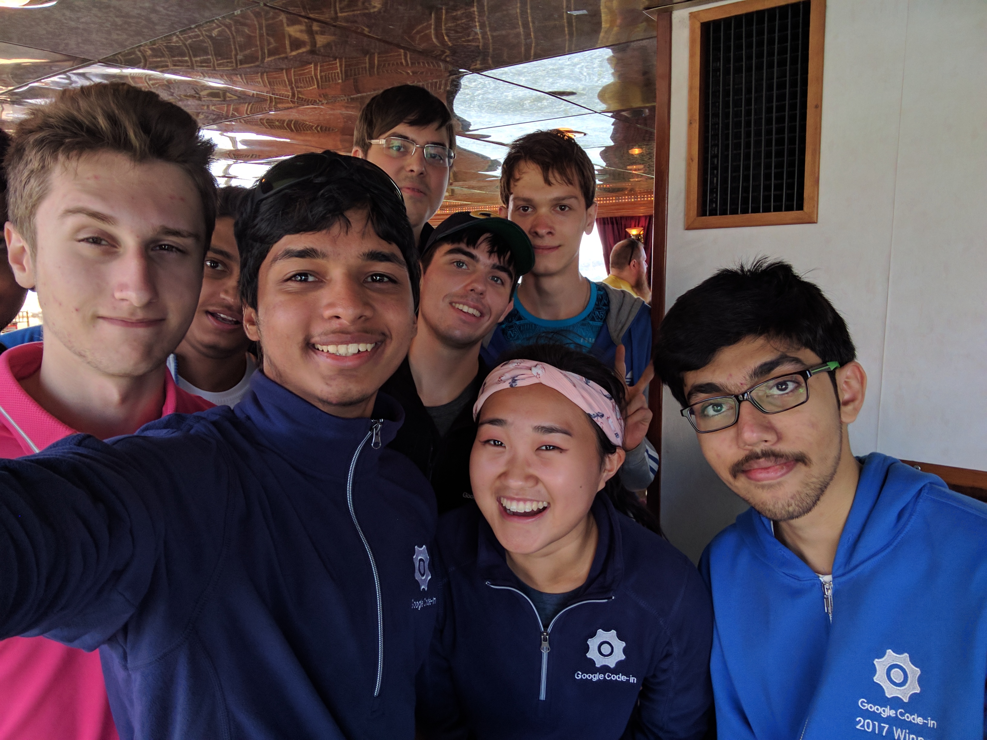 Google Code-In winners taking a group selfie on a boat